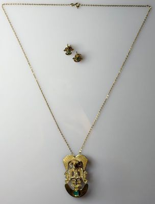 a necklace and earring set with a gold buddha pendant