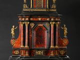 une très vieille horloge exposée sur un socle