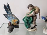 three figurines of a boy carrying grapes on a glass shelf