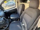 the interior of a small van with two seats and a steering wheel