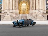 a blue vintage car parked in front of a large building