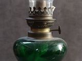 une lampe en verre vert posée sur une table