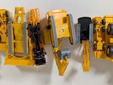 yellow and black toy vehicles are lined up on a white surface