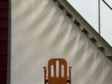 a wooden chair sitting in front of a set of stairs