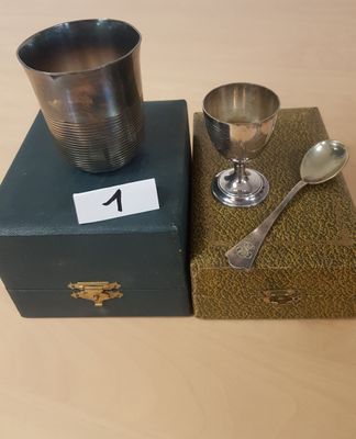 une tasse et une cuillère en argent posées sur une boîte