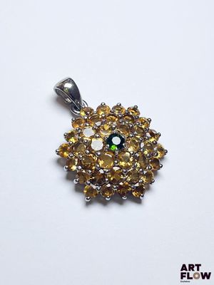 une image représentant un pendentif en forme de diamant jaune et blanc posé sur une surface blanche