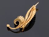 an image of a gold plated brooch with a leaf design on it