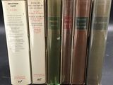 several books are lined up in a row on a table