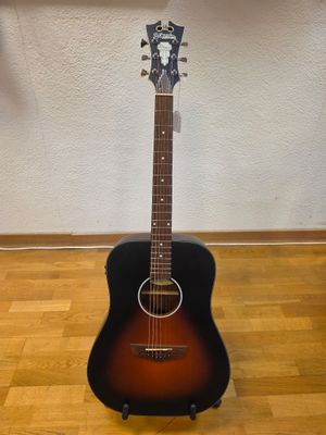 an acoustic guitar sitting on a hard wood floor next to a wall