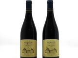 two bottles of red wine sitting next to each other on a white surface