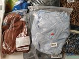 many different types of clothing in bags on the table