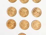 several gold coins are arranged in a triangle on a white surface