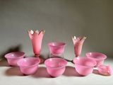 beaucoup de bols et de tasses roses posés sur une table