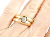 an image of a woman ' s hand holding a gold ring with a diamond
