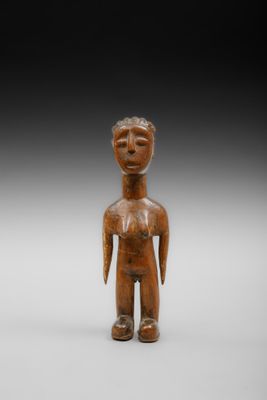 une petite figurine en bois représentant un homme les bras croisés