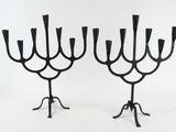pair of black iron candelabs with candlesticks on stands