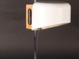 une lampe blanche avec un socle en bois sur fond noir