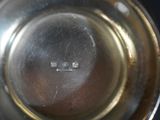 a close up of a silver plate with a black background