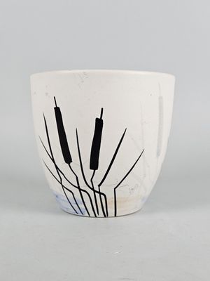 a white cup with black cattails on it
