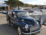 une voiture bleue garée à côté de quelques bateaux