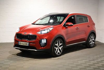 une voiture rouge garée dans un garage au sol en damier