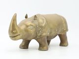 a small bronze statue of a rhino on a white background