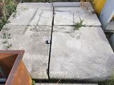 des toilettes cassées posées sur le trottoir, à côté d'une poubelle