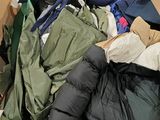 une boîte en carton remplie de vêtements, ainsi que des vêtements éparpillés sur le sol