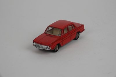 une petite voiture rouge sur une surface blanche