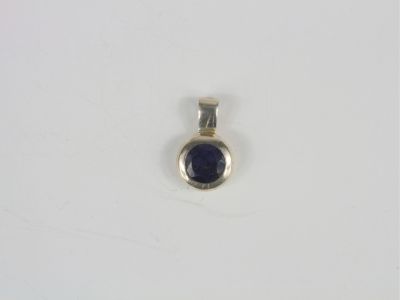 a close up of a silver and blue stone pendant on a white surface