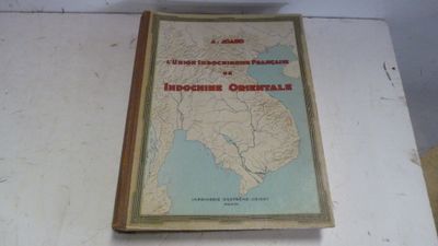 un vieux livre sur lequel figure une carte, posé sur une table