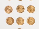 a close up of a bunch of gold coins on a white surface