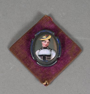 une petite image représentant un homme coiffé d'un chapeau, posé sur un tissu violet