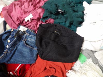 a pile of clothes that is on a bed