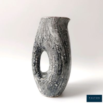 un vase noir et blanc percé d'un trou