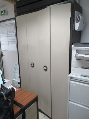 un réfrigérateur blanc et une imprimante noir et blanc posés sur un bureau