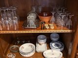 a wooden cabinet with many glasses and plates on it