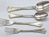 five silver spoons and a fork on a table