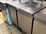 des plans de travail en acier inoxydable dans une cuisine professionnelle offrant un grand espace de travail