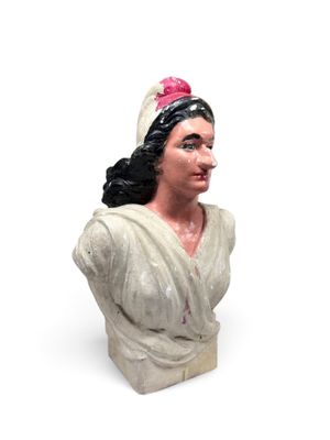 statue d'une femme en robe blanche, avec une fleur rose dans les cheveux