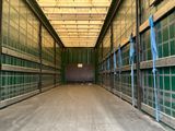 une photo d'un grand local de stockage vide aux murs verts