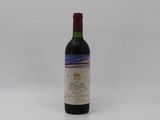 a bottle of red wine sitting on top of a white table