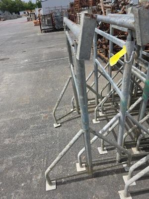 beaucoup d'échafaudages métalliques posés au sol dans un parking
