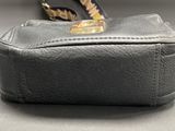 a black purse with a feather on it on a table