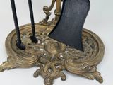 a black and gold clock on a stand with two candles