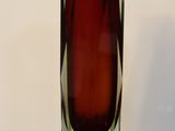 a red glass vase sitting on a black table