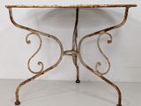 an old iron table with a marble top on a white floor