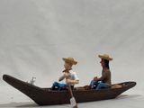 two figurines of a man and a woman in a boat