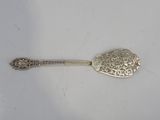 silver spoon with ornate design on it on a white surface