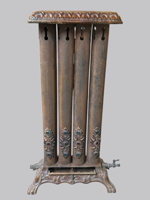 un grand radiateur en métal sur lequel sont posées quatre bougies